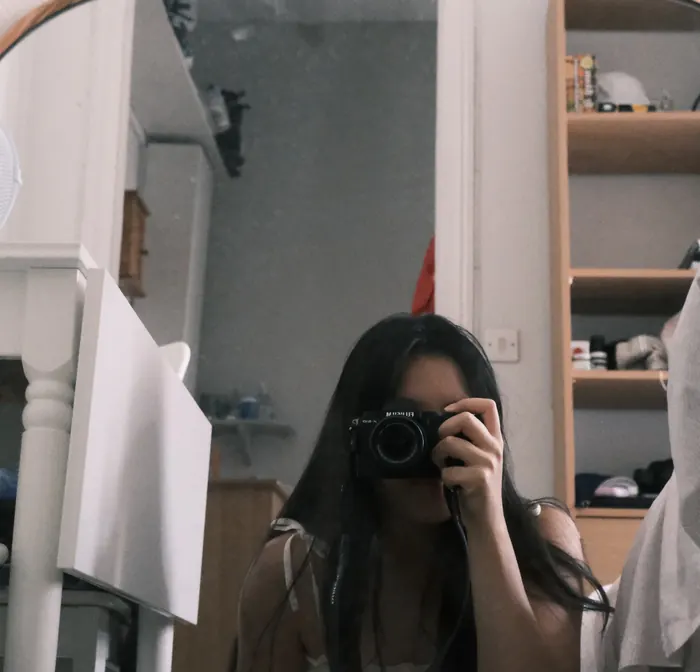 Cathy se prend en photo dans un miroir, son appareil devant le visage
